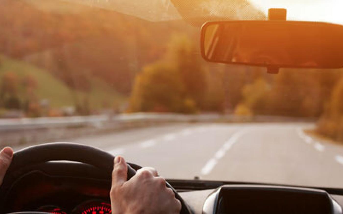 driver looking forward towards the road with their eyes reflected in the rearview mirror