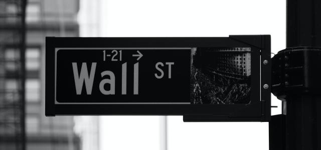 grayscale photo of Wall St. signage by Patrick Weissenberger courtesy of Unsplash.
